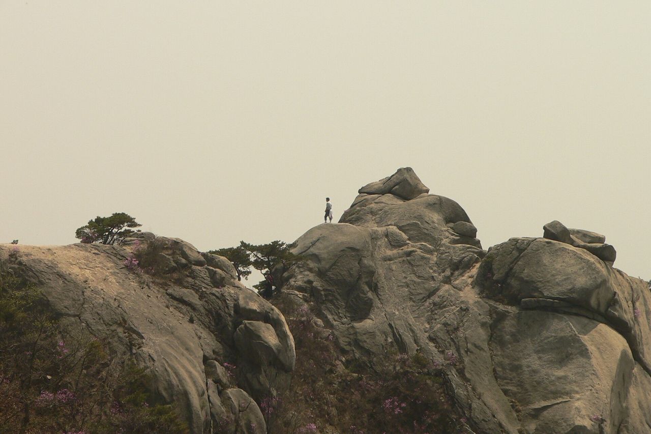 봄 — 진달래 핀 봄 암릉. 바위 위 등산객이 점처럼 서 있다. ⓒWikimed