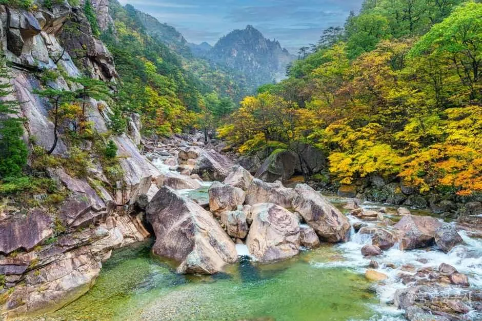 Boulders and a stream in an Outer Seorak gorge with autumn foliage